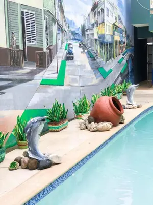 a swimming pool with a mural of a city at Hotel Sinai in Nagua