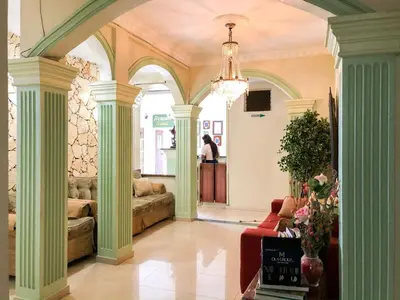 a lobby with green columns and a chandelier at Hotel Sinai in Nagua