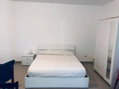 a bedroom with a white bed and a chair at Apartamento estudio frente al mar in Guayacanes