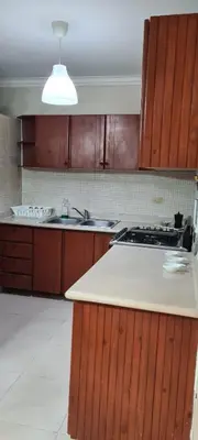 a kitchen with wooden cabinets and a counter top at Vistabalcon Aire y Neflix in La Guáyiga