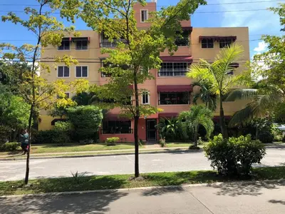 an empty street in front of a pink building at Vistabalcon Aire y Neflix in La Guáyiga
