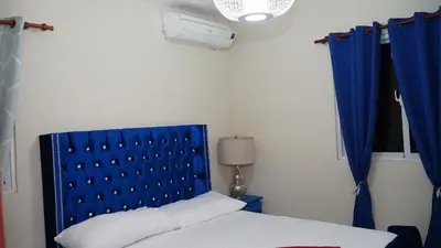 a bed with a blue headboard in a room at Vistabalcon Aire y Neflix in La Guáyiga