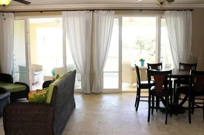 a living room with a table and chairs and a dining room at Cozy and Luxurious 2 bedroom apartment in Sosúa