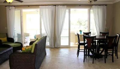 a living room with a dining room table and chairs at Cozy and Luxurious 2 bedroom apartment in Sosúa