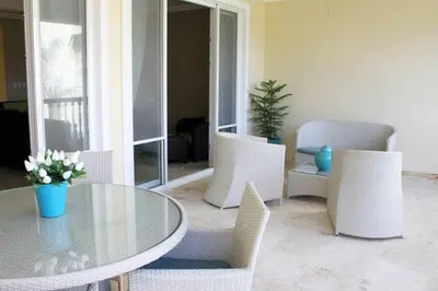 a dining room with a glass table and white chairs at Cozy and Luxurious 2 bedroom apartment in Sosúa