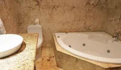a bathroom with a tub and a toilet and a sink at Cozy and Luxurious 2 bedroom apartment in Sosúa