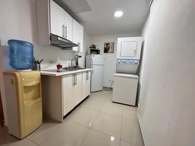 a small kitchen with white appliances and white cabinets at Paradise Suite Cadaqués in Bayahibe