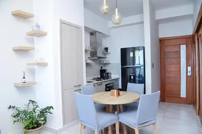 a kitchen with a wooden table and blue chairs at S1404 Vista espectacular Downtown Santo Domingo in Santo Domingo