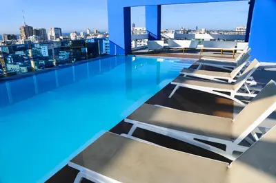 a swimming pool with lounge chairs on the roof of a building at S1404 Vista espectacular Downtown Santo Domingo in Santo Domingo