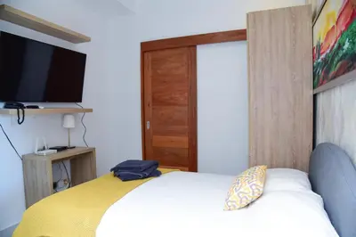 a bedroom with a bed with a television and a door at S1404 Vista espectacular Downtown Santo Domingo in Santo Domingo