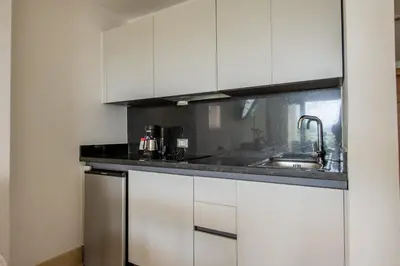 a kitchen with white cabinets and a sink at Hacienda Samana Bay Hotel in Santa Bárbara de Samaná