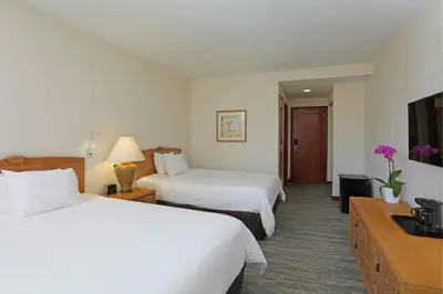 a hotel room with two beds and a television at Four Points by Sheraton Santo Domingo in Santo Domingo