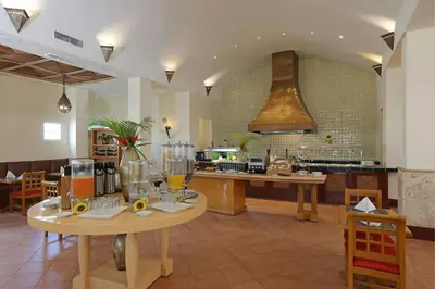 a large kitchen with two tables in a room at Four Points by Sheraton Santo Domingo in Santo Domingo