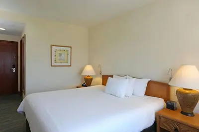 a hotel room with a large white bed with two lamps at Four Points by Sheraton Santo Domingo in Santo Domingo