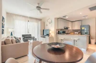 a living room with a table and a kitchen at Newly Added 1BR El Portillo Luxury in Portillo