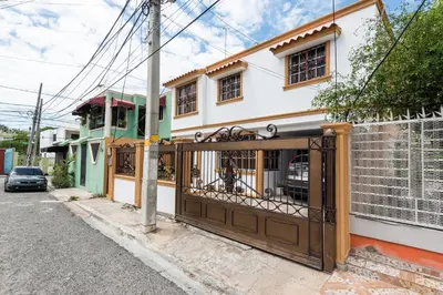 a house with a gate in front of it at Acogedor Espacio en Santo Domingo Este. in Mandinga