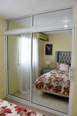 a bedroom with a sliding glass door leading to a bed at Acogedor Espacio en Santo Domingo Este. in Mandinga