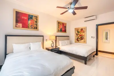 a bedroom with two beds and a ceiling fan at Townhouse with ocean view Puerto Bahia in Los Grini