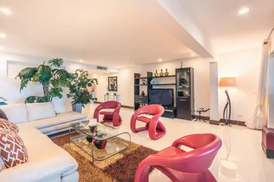 a living room with red chairs and a couch at Townhouse with ocean view Puerto Bahia in Los Grini
