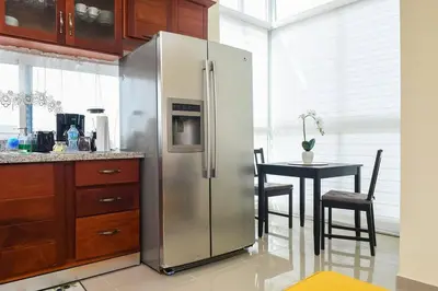 a stainless steel refrigerator in a kitchen with a table at Maravilloso Apto en Santo Domingo in Santo Domingo