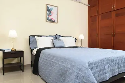 a bedroom with a bed with a blue comforter and two lamps at Maravilloso Apto en Santo Domingo in Santo Domingo