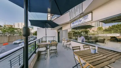 an outdoor patio with tables and chairs and umbrellas at Breakfast Included Fully Serviced Apartment at Regatta Living II - 204 in Santo Domingo