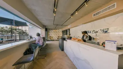 a woman sitting at a counter in a restaurant at Breakfast Included Fully Serviced Apartment at Regatta Living II - 204 in Santo Domingo