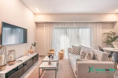 a living room with a couch and a tv at Breakfast Included Fully Serviced Apartment at Regatta Living II - 204 in Santo Domingo