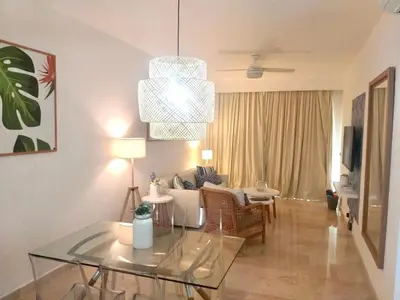 a living room with a glass table and a couch at Cana Rock De Lujo 344 Vista Al Campo De Golf in Punta Cana