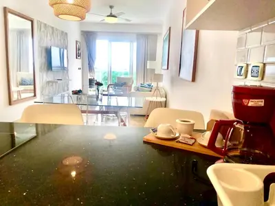 a kitchen and living room with a table and a dining room at Cana Rock 351 Impresionante Vista A La Piscina in Punta Cana