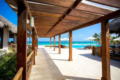 a pavilion at the beach with the ocean in the background at Apartamento 120 Jardin Privado Cana Rock in Punta Cana