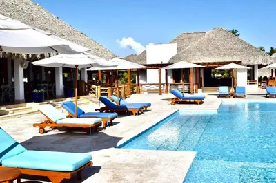 a swimming pool with lounge chairs and umbrellas at Apartamento 120 Jardin Privado Cana Rock in Punta Cana