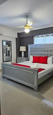 a bedroom with a large bed with red pillows at LEAN LUXURY Santo Domingo in Santo Domingo