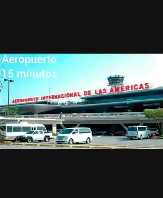 a sign for an airport with cars parked in a parking lot at 3bed Apartment con Terraza y Picsina privada in Santo Domingo