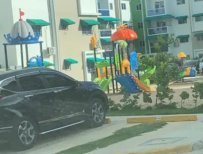 a black car parked in front of a playground at 3bed Apartment con Terraza y Picsina privada in Santo Domingo