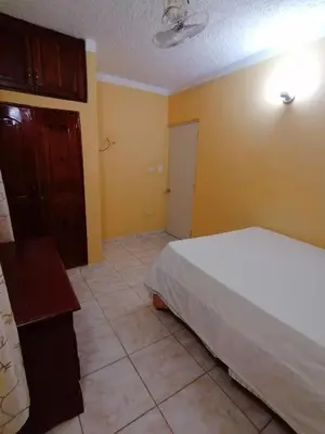a bedroom with a white bed and a yellow wall at Las colinas de Samaná in Santa Bárbara de Samaná