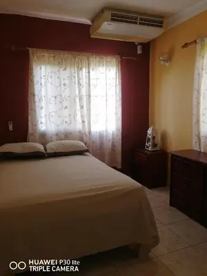 a bedroom with a bed and a window with curtains at Las colinas de Samaná in Santa Bárbara de Samaná
