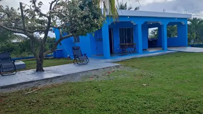 a blue house with chairs in a yard at Casa A&A in Las Galeras