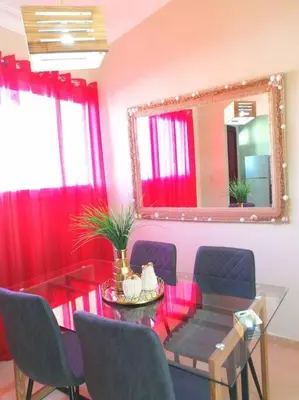 a dining room with a table and a mirror at Acogedor-Hermoso apart completo equipado de 2 hab. in Santiago de los Caballeros