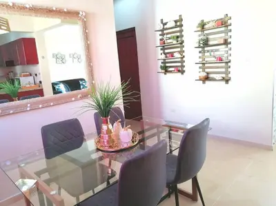 a dining room with a glass table and chairs at Acogedor-Hermoso apart completo equipado de 2 hab. in Santiago de los Caballeros
