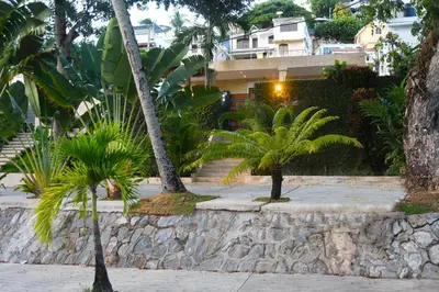 two palm trees in front of a building at Villa Dylan Samana, Luxury 3Br with pool in Santa Bárbara de Samaná