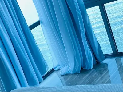 a window with blue curtains on a cruise ship at Malecón vista mar Habitación Privada Larimar, in Santo Domingo