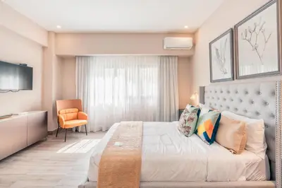 a bedroom with a large bed and a chair at Apartment at Regatta Living II - 406 fully-equipped in Los Prados