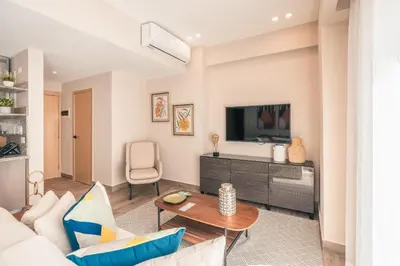 a living room with a couch and a tv at Apartment at Regatta Living II - 406 fully-equipped in Los Prados