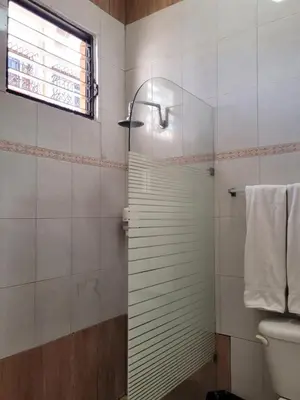a shower with a glass door in a bathroom at Drake Bolivar Santo Domingo in Santo Domingo