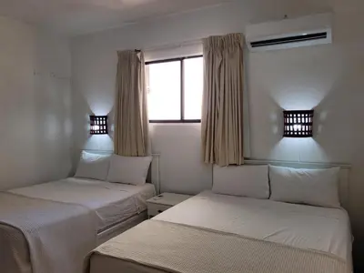 two beds in a room with a window at Drake Bolivar Santo Domingo in Santo Domingo
