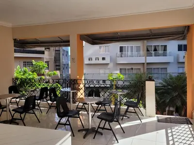 a patio with tables and chairs on a balcony at Drake Bolivar Santo Domingo in Santo Domingo