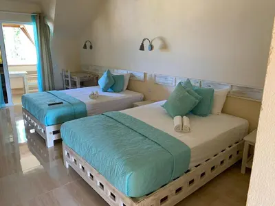 a bedroom with two beds with blue pillows at guest house MY WAY in Las Terrenas
