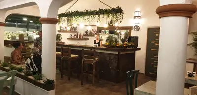 a bar in a restaurant with people sitting at it at PLAYA BLANCA BED AND BREAKFAST in Bayahibe