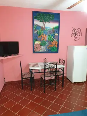 a dining room with a table and a refrigerator at PLAYA BLANCA BED AND BREAKFAST in Bayahibe
